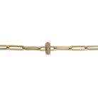 A 14k gold paperclip chain with a curved edge diamond roundel bead made of 14k gold with a pattern of inset and prominent diamonds creating a roundel design.