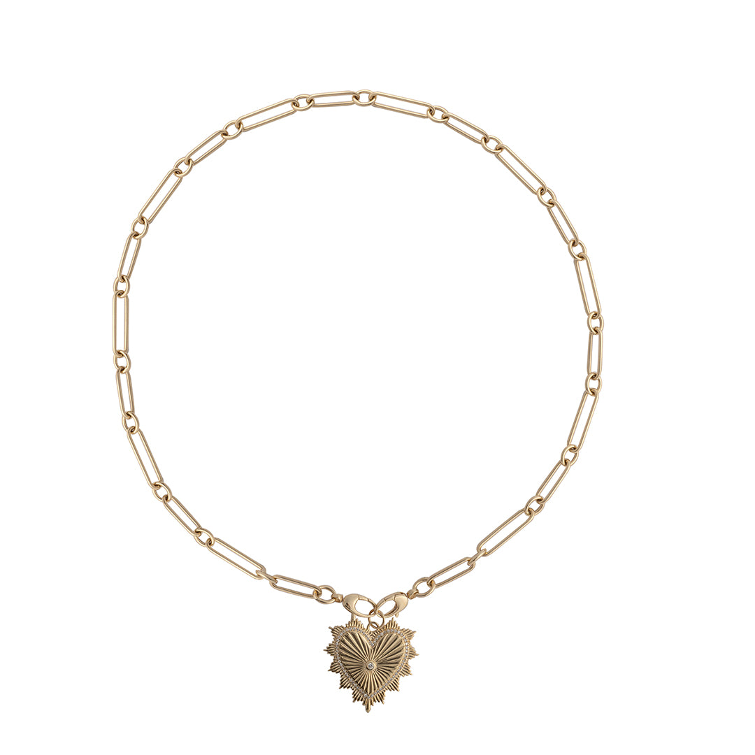 A 14k gold chain with two clasps attached together, holding a heart charm set on a white background. 