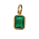 A 14k gold mini pendant with a emerald stone, set on a white background.