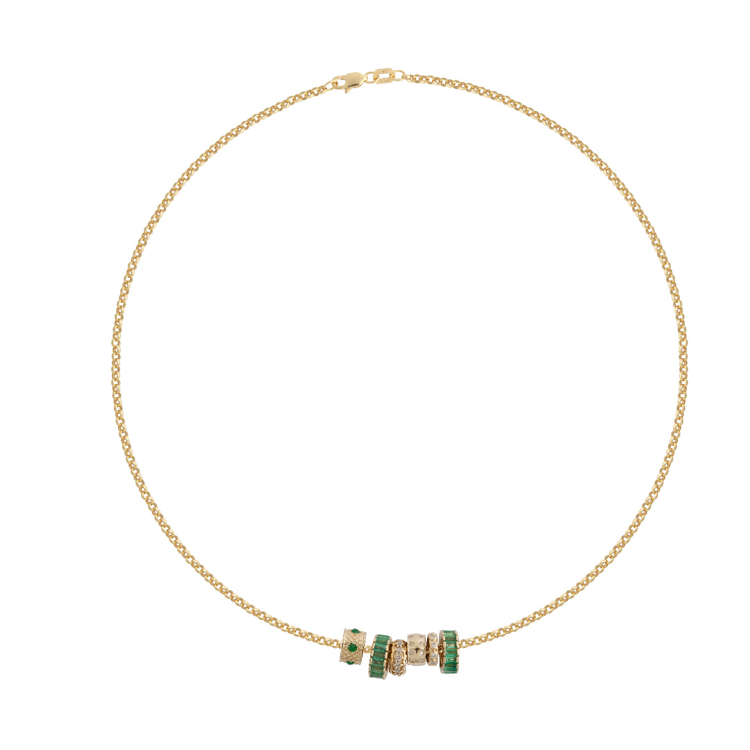 A gold necklace with emerald and diamond beads set on a white background. 