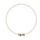 A gold necklace with emerald and diamond beads set on a white background. 