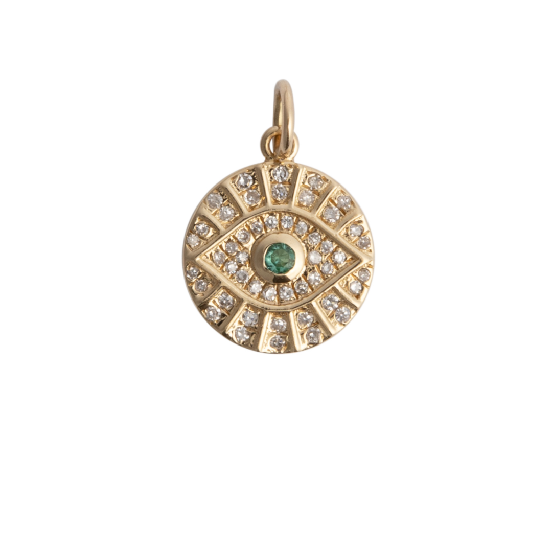 A gold pendant featuring a circular design with diamonds and emeralds, attached to a small chain.