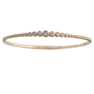 A 14k gold bangle bracelet featuring a series of graduated round diamonds, with a secure clasp on the back.