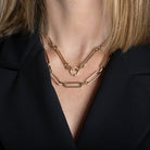 A person modeling two 14k gold necklaces with diamond links. 