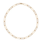 A gold paperclip link chain necklace laid out on a plain background.