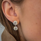 A close-up of a person's ear wearing lab-grown studs and earring jackets, both set in white gold. 