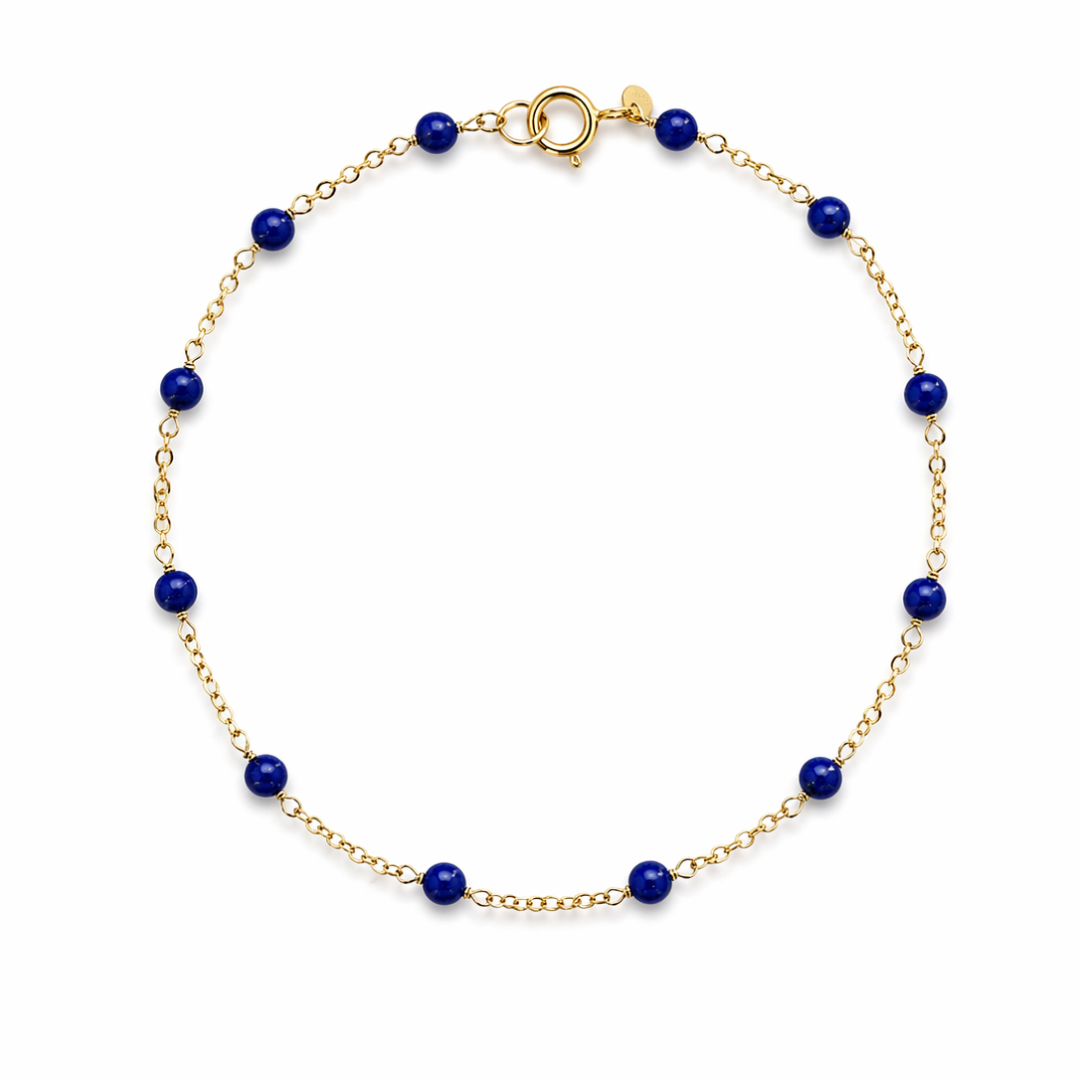14k gold bracelet with lapis beads on a white background.