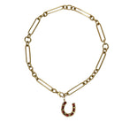 14k gold chain necklace with a horseshoe charm on a white background.