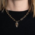 A gold chunky u-link chain with a gold Long Heart Sunrays Pendant attached. 