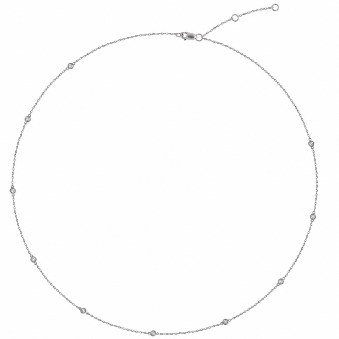 A 14k white gold chain necklace with a series of diamonds stations throughout the chain.