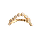 Gold ring with bezel set diamonds on a white background.