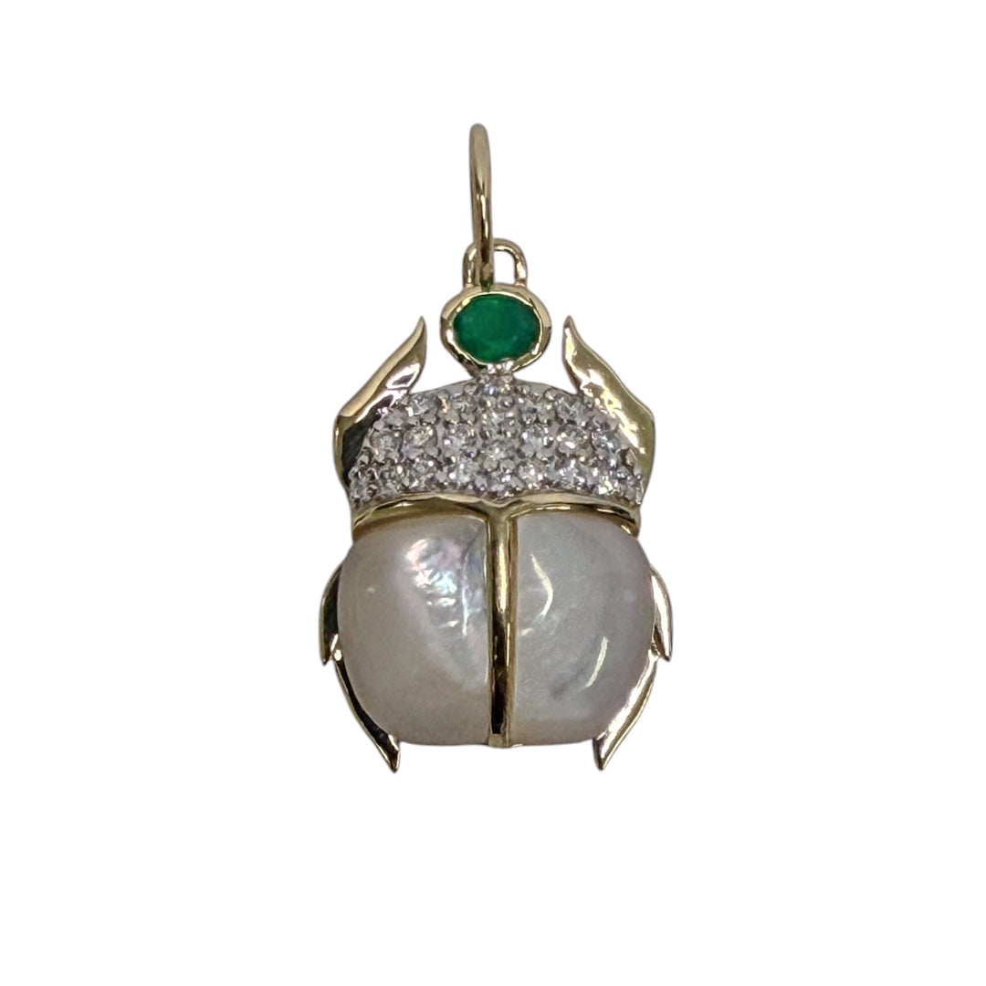 A 14k gold scarab pendant with mother of pearl, diamond and green onyx stones all set on a white background. 
