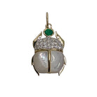 A 14k gold scarab pendant with mother of pearl, diamond and green onyx stones all set on a white background. 