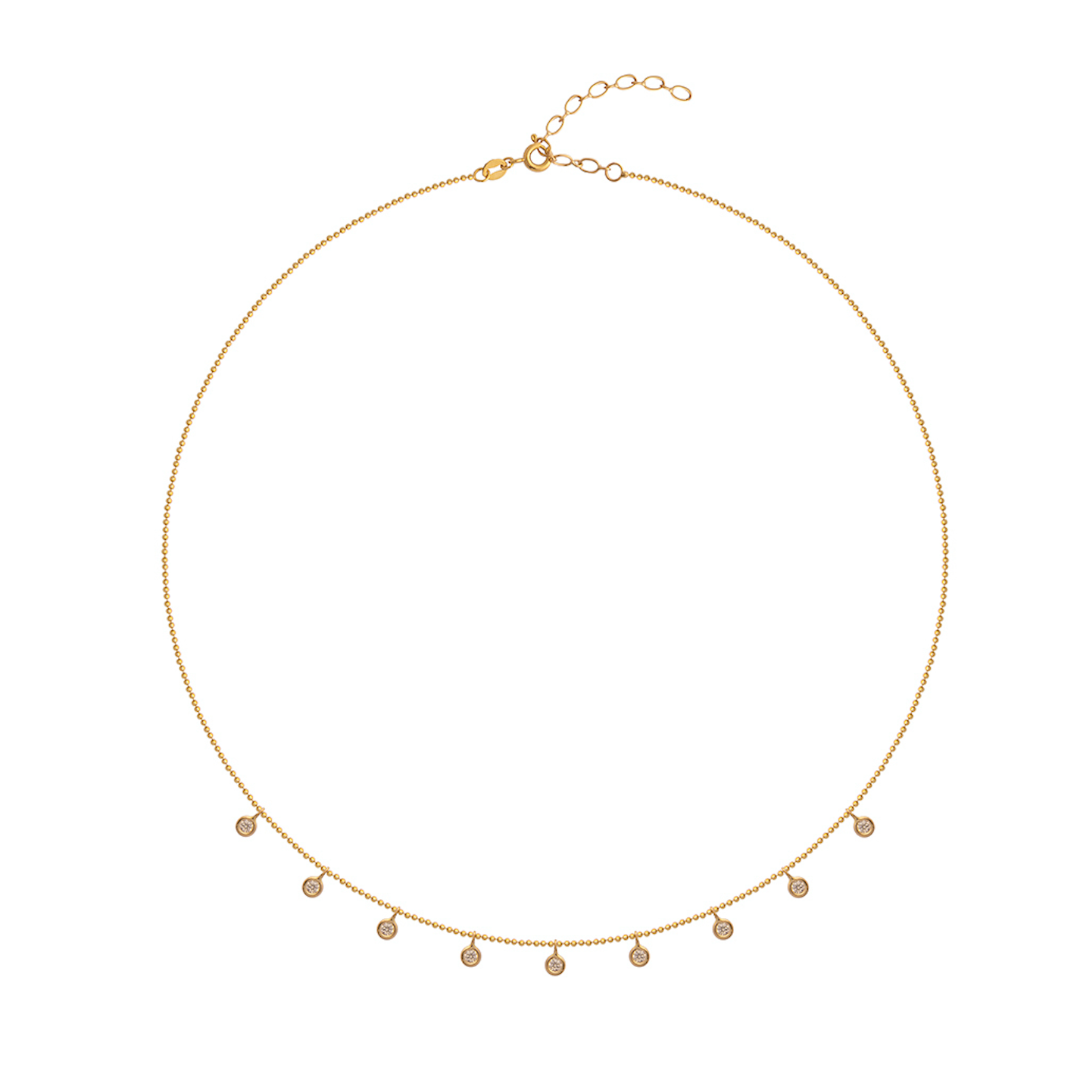 Gold necklace with small bezel set diamond pendants on a white background