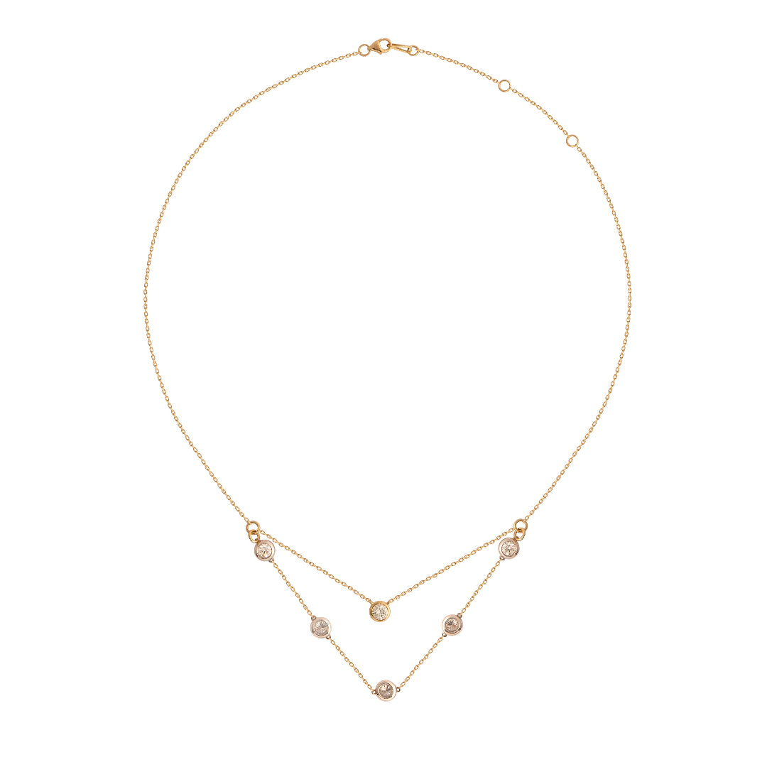 Gold necklace with bezel set diamonds on a white background