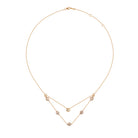 Gold necklace with bezel set diamonds on a white background