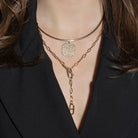 Close-up of a person wearing two necklaces with a black blazer