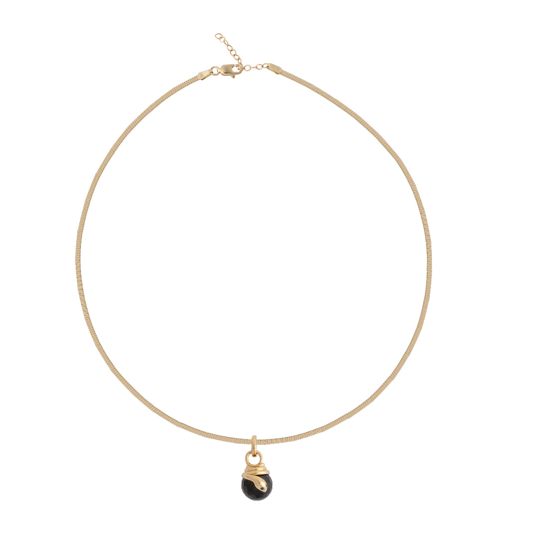 Gold necklace with a black pendant on a white background