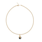 Gold necklace with a black pendant on a white background