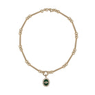 A 14k gold necklace with a double-sided diamond enhancer, featuring oval and round link chains with a malachite pendant attached. 