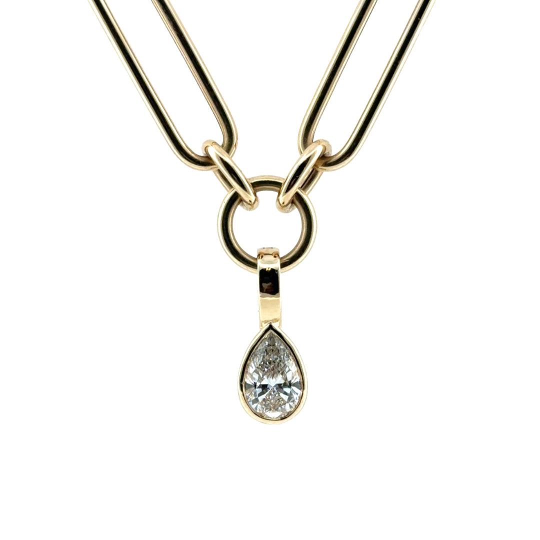 A close-up of a pear lab grown diamond pendant, set in 14k gold on a chunk chain all on a white background. 
