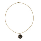Gold necklace with a round pendant on a white background