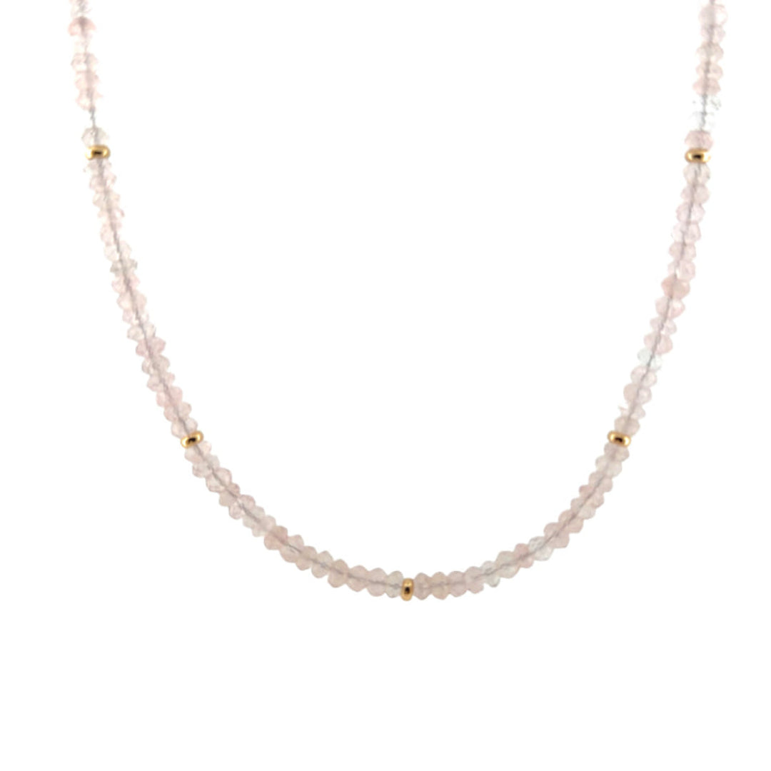 A close-up of a rose quartz necklace with 14k gold beads on a white background.