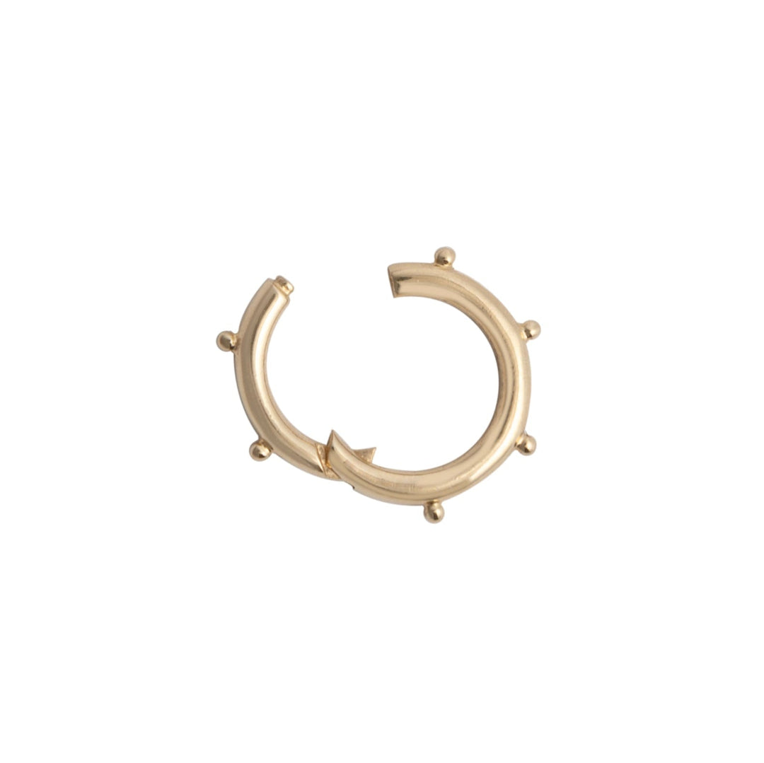 A gold round dotted pendant bail with multiple dots around its circumference.