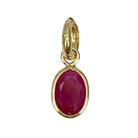 A ruby pendant set in 14k gold on a white background. 