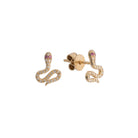 Gold snake-shaped earrings with diamond pavé and pink sapphire eyes  on a white background