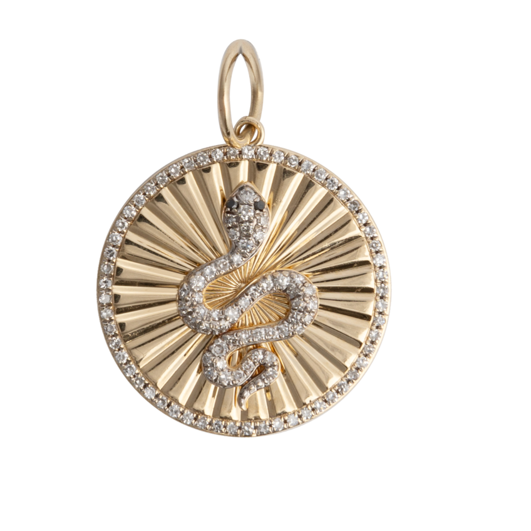 A 14k gold pendant featuring a diamond-set serpent with black diamond eyes, surrounded by a starburst pattern with diamond border.