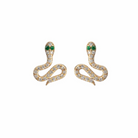 Gold snake-shaped earrings with pave diamonds and emerald eyes on a white background