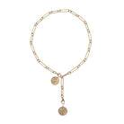 A 14k gold chain necklace styled lariat style with two serpent pendants, on a white background