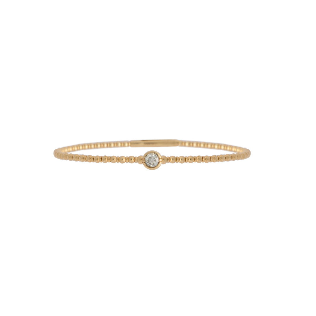 Gold bracelet with a single station diamond on a white background