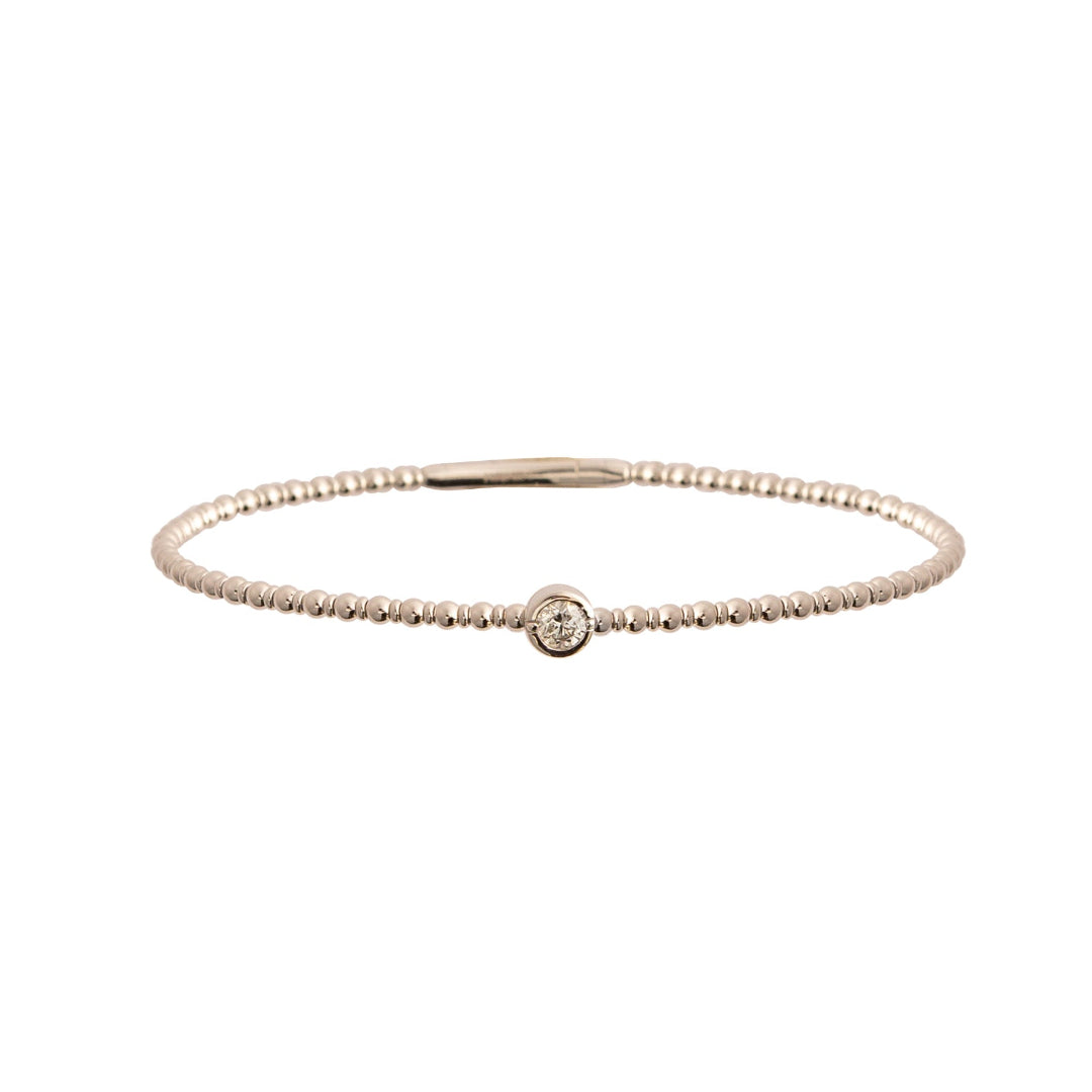 White gold bracelet with a single station set diamond on a white background.