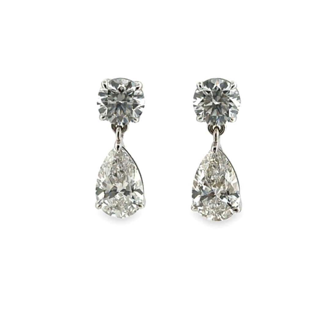 A pear of Solitare Studs with Pear Lab-Grown Diamond Drop Earrings on a white background. 