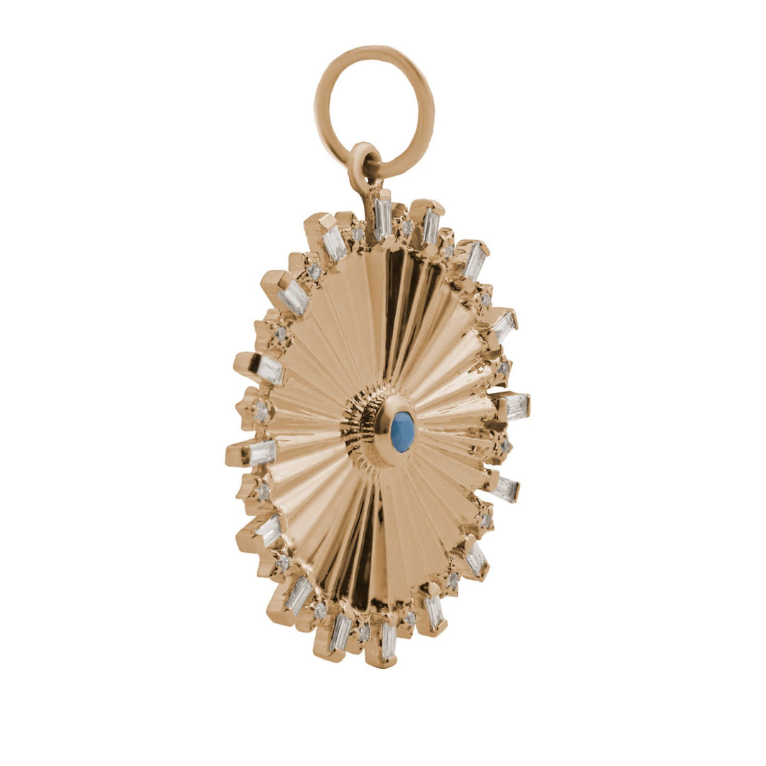 A sideways shot of a gold circular pendant with diamonds and a turquoise center. 