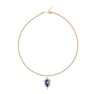 Gold necklace with a blue teardrop pendant on a white background