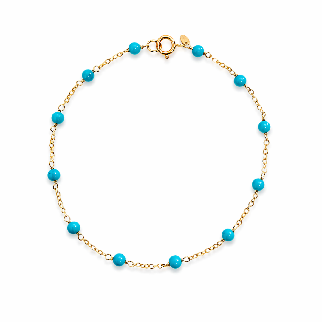 Turquoise beaded bracelet on a 14k gold chain against a white background