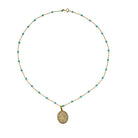 14k gold necklace with turquoise beads and a pavé diamond gold pendant on a white background. 