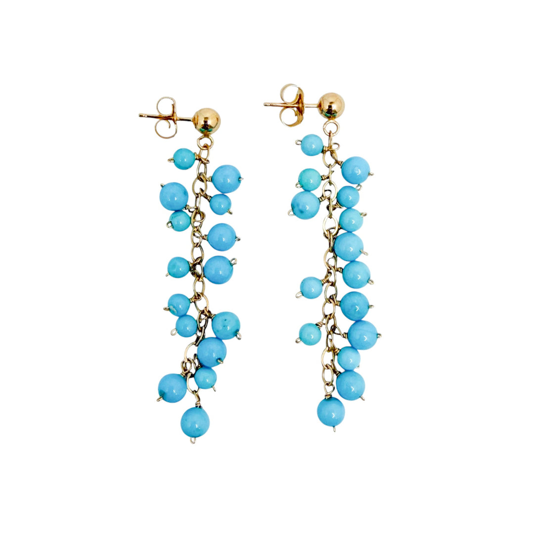 Pair of turquoise beaded earrings set in 14k gold on a white background.