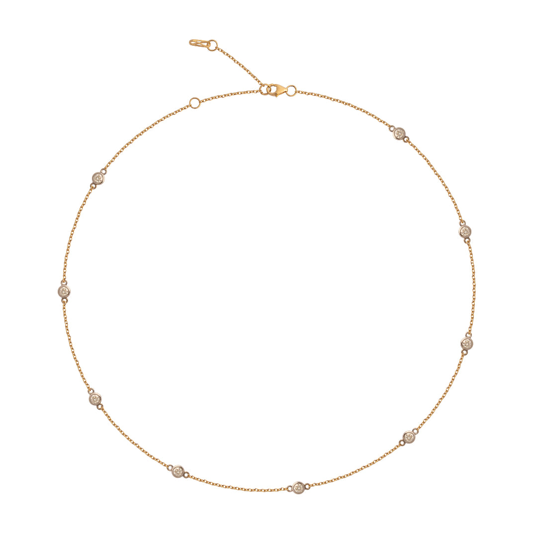 Gold necklace with white gold bezels containing diamonds on a white background