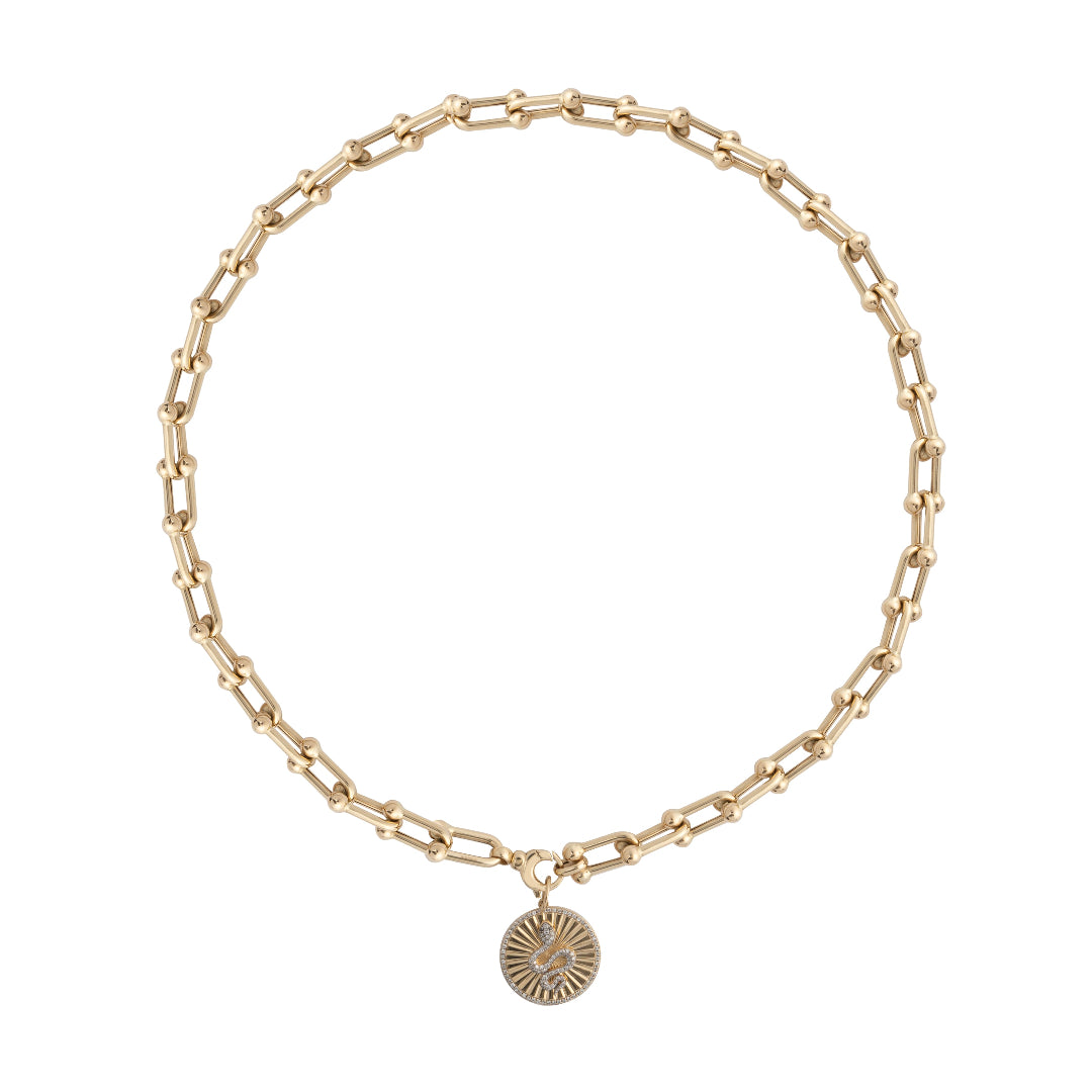 A chunky gold necklace with a diamond serpent pendant. 