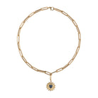 A chunky paperclip chain necklace with a gold pendant attached with agold pendant bail, laid out on a white background.