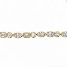 A close-up of a yellow gold tennis bracelet featuring a continuous row of round, emerald-cut, and marquise-cut diamonds on a plain white background.