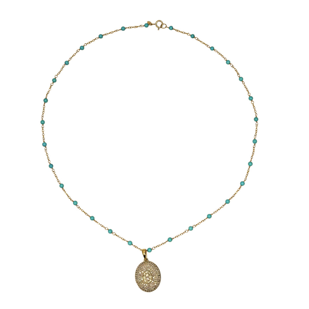 Necklace with turquoise beads and a pave diamond gold pendant on a white background